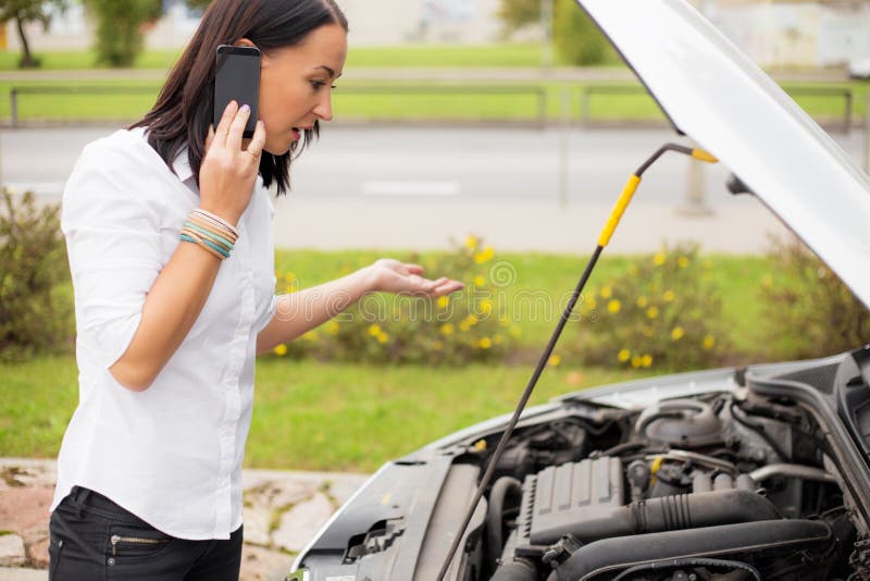 Vrouw die zich naast gebroken auto bevinden en op telefoon spreken royalty-vrije stock afbeeldingen Vrouw die zich naast gebroken auto bevinden en op telefoon spreken royalty-vrije stock afbeeldingen