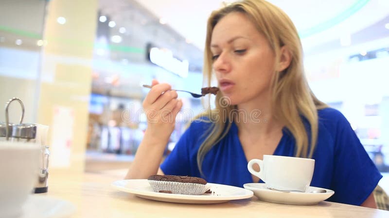 Vrouw in een koffie het drinken koffie met chocoladecake