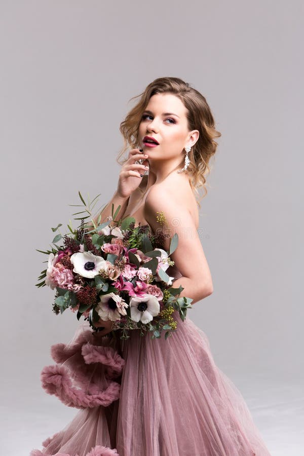 Vrouw in een roze kleding met bloemboeket royalty-vrije stock foto Vrouw in een roze kleding met bloemboeket royalty-vrije stock foto