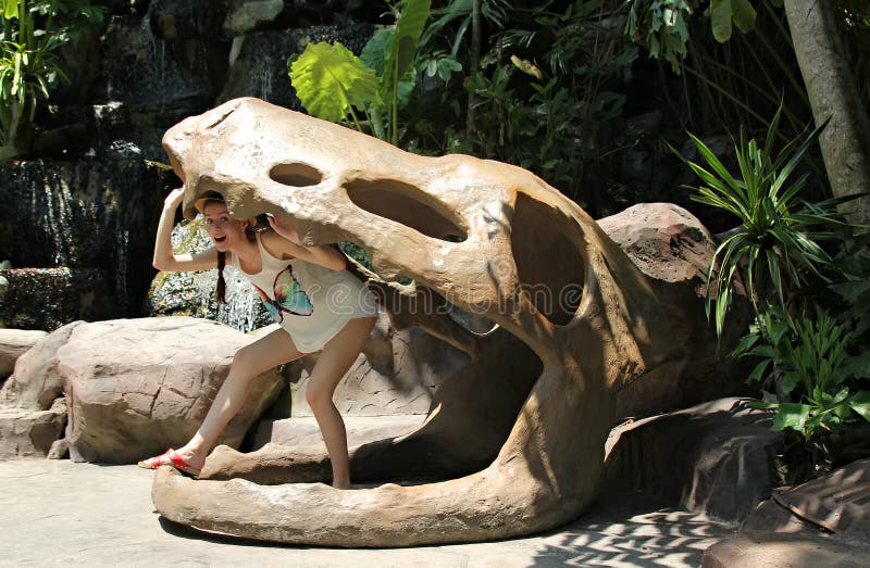 Vrouw in een valse schedel van een dinosaurus stock afbeelding Vrouw in een valse schedel van een dinosaurus stock afbeelding