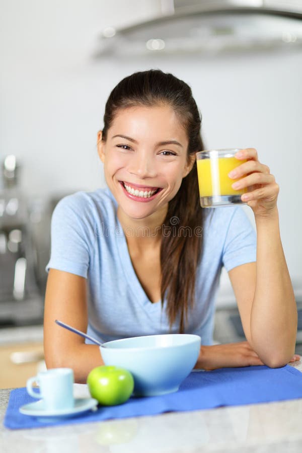Vrouw het drinken jus d'orange die ontbijt eten royalty-vrije stock foto Vrouw het drinken jus d'orange die ontbijt eten royalty-vrije stock foto