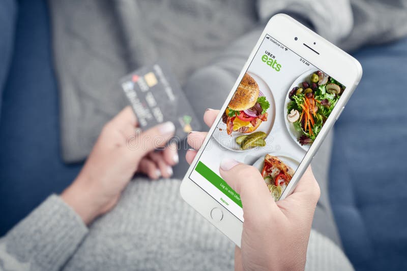 Vrouw die de Uber Eats-app gebruikt op een Apple iPhone 8 Plus royalty-vrije stock foto's