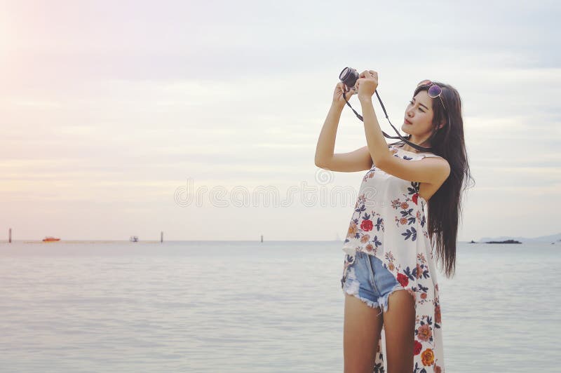 Vrouw het gelukkige neemt glimlachen en een camera op het strand op een beautifu stock foto's Vrouw het gelukkige neemt glimlachen en een camera op het strand op een beautifu stock foto's