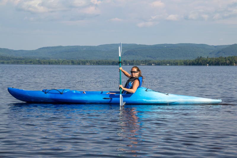 Vrouw het kayaking op een kalm meer stock fotografie Vrouw het kayaking op een kalm meer stock fotografie
