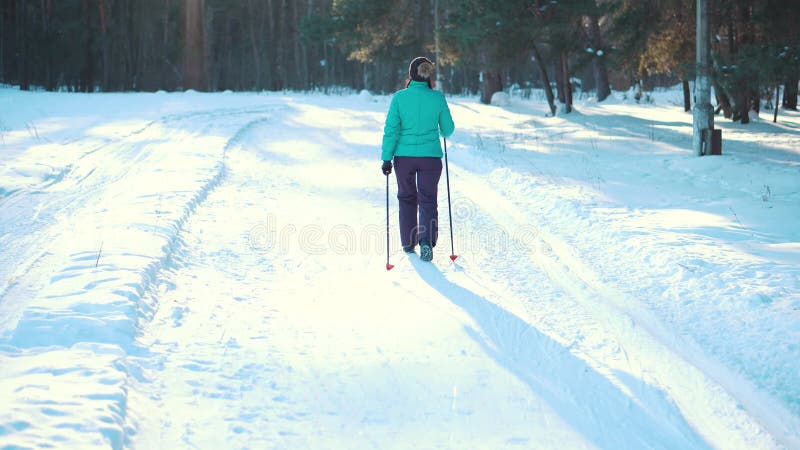 Vrouw het noordse lopen in de winterpark