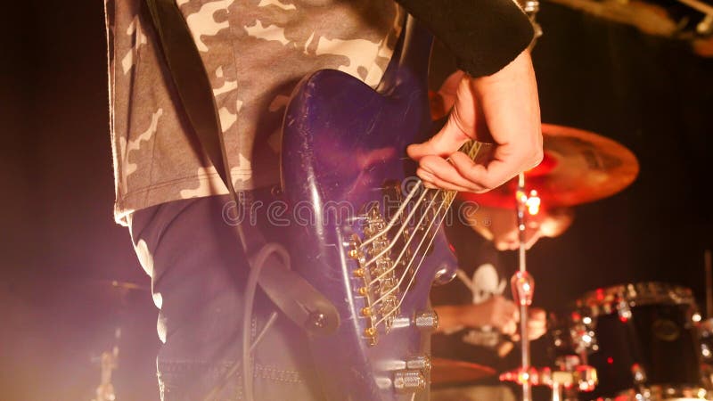 Vrouw het spelen zingende kom en het zingen, in purpere en blauwe verlichting De gitarist speelt de gitaar E sigh die op witte ac royalty-vrije stock afbeeldingen Vrouw het spelen zingende kom en het zingen, in purpere en blauwe verlichting De gitarist speelt de gitaar E sigh die op witte ac royalty-vrije stock afbeeldingen