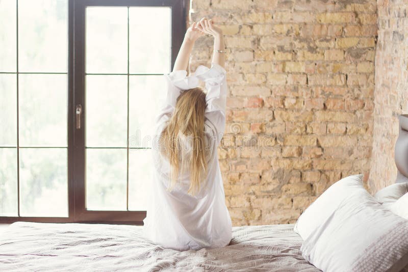 Vrouw het uitrekken zich in bed na ontwaken royalty-vrije stock afbeelding Vrouw het uitrekken zich in bed na ontwaken royalty-vrije stock afbeelding