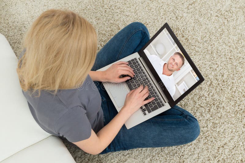 Vrouw die via video met een man op een laptop chat stock afbeelding