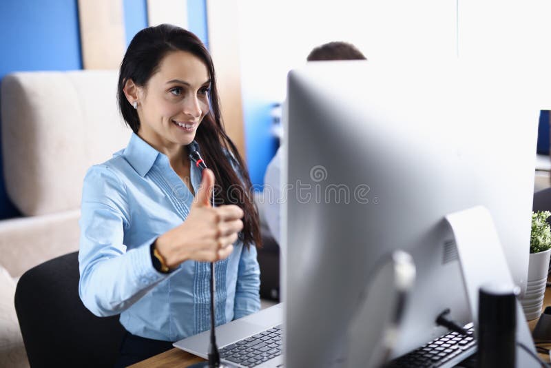 Woman holds thumbs up and communicates on an online call. Successful development of online learning concept. Woman holds thumbs up and communicates on an online call. Successful development of online learning concept.