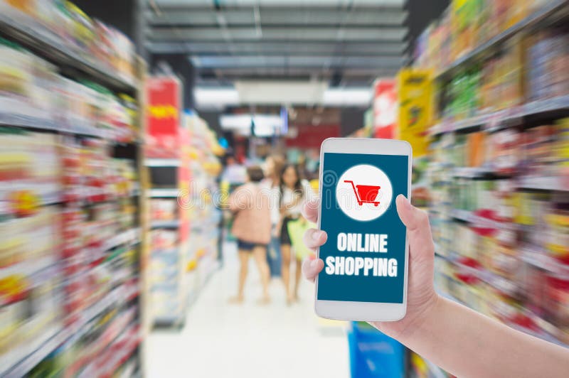 Vrouw houdt smartphone vast en betaalt online in de supermarkt van de onduidelijke achtergrond, concept online winkelen met elekt royalty-vrije stock fotografie Vrouw houdt smartphone vast en betaalt online in de supermarkt van de onduidelijke achtergrond, concept online winkelen met elekt royalty-vrije stock fotografie