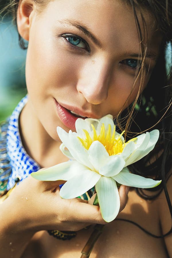 Vrouw met blauwe ogen met stroomversnellinglelie ter beschikking royalty-vrije stock fotografie Vrouw met blauwe ogen met stroomversnellinglelie ter beschikking royalty-vrije stock fotografie