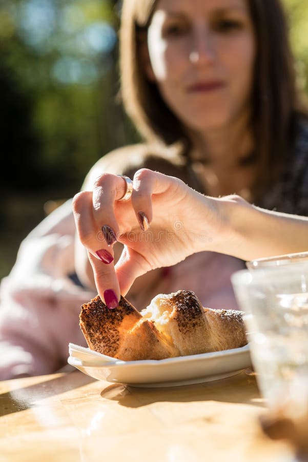 Vrouw met een baby die een stuk van croissant verwijderen uit een plaat royalty-vrije stock afbeeldingen Vrouw met een baby die een stuk van croissant verwijderen uit een plaat royalty-vrije stock afbeeldingen
