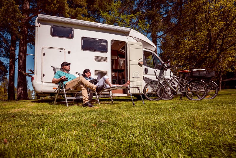 Vrouw met een man die dichtbij motorhomes in aard rusten Familie vacat stock foto Vrouw met een man die dichtbij motorhomes in aard rusten Familie vacat stock foto