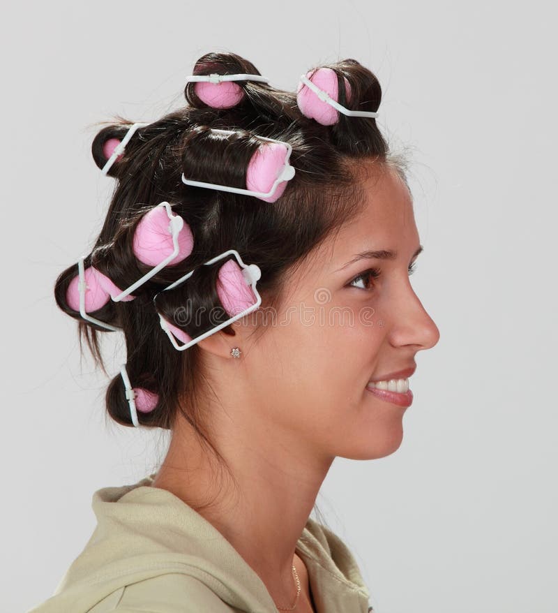 Profile of a young woman with hair curlers on her head. Profile of a young woman with hair curlers on her head.