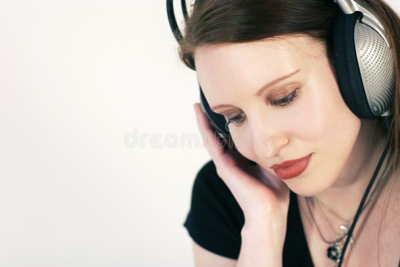 A beautiful young woman listen to usic with headphones. A beautiful young woman listen to usic with headphones.