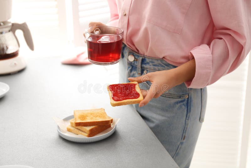 Vrouw met lekker ontbijt met toast en frambozen thee Morinaire routine stock foto Vrouw met lekker ontbijt met toast en frambozen thee Morinaire routine stock foto