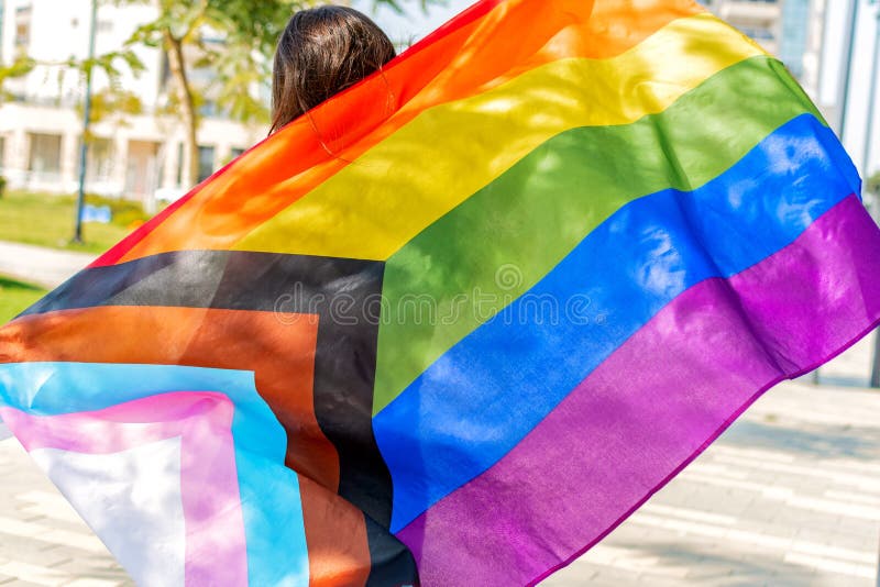 Vrouw met lgbtq zet de vlag van de regenboog in de trots