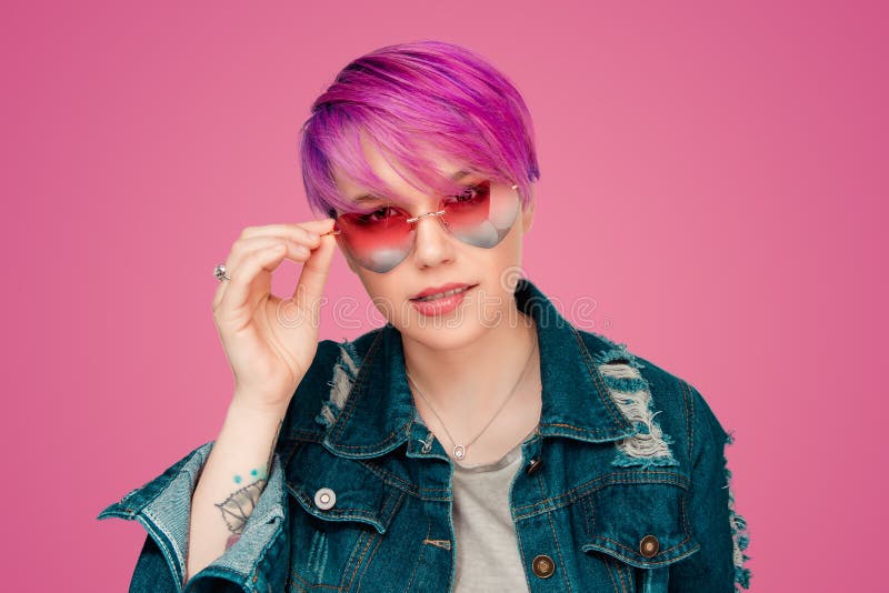 Vrouw met magenta purpere haarholding die roze hart gevormde zonnebril tonen royalty-vrije stock foto Vrouw met magenta purpere haarholding die roze hart gevormde zonnebril tonen royalty-vrije stock foto