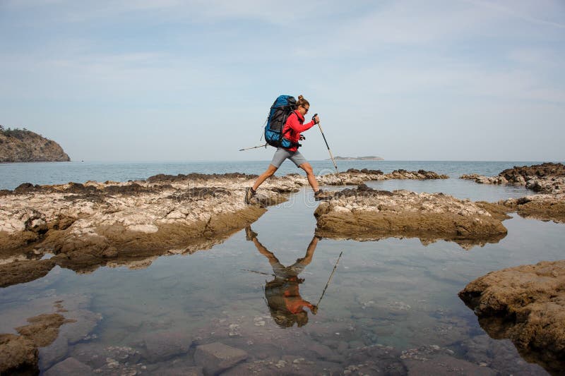 Vrouw met rugzaktreks op een overzeese kust stock foto Vrouw met rugzaktreks op een overzeese kust stock foto