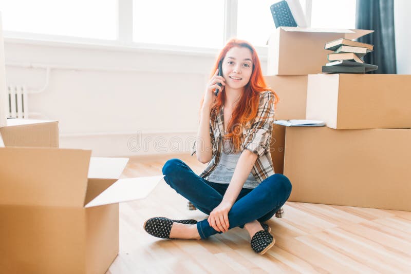 Vrouw onder kartondozen die telefonisch spreken stock afbeeldingen Vrouw onder kartondozen die telefonisch spreken stock afbeeldingen