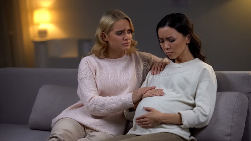 Vrouw ondersteunend haar verstoorde zwangere vriend, die hand, enige toekomstige moeder houden stock foto's Vrouw ondersteunend haar verstoorde zwangere vriend, die hand, enige toekomstige moeder houden stock foto's