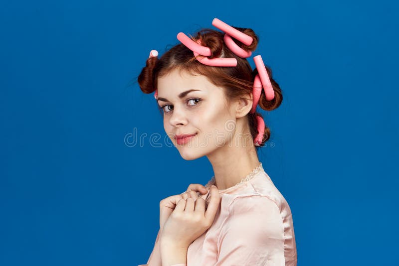 Vrouw op blauwe achtergrond, huisvrouw, kapsel, haarkrulspelden, portret royalty-vrije stock foto's Vrouw op blauwe achtergrond, huisvrouw, kapsel, haarkrulspelden, portret royalty-vrije stock foto's