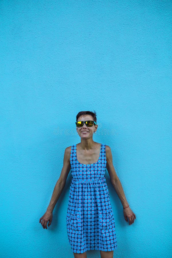 Vrouw tegen een blauwe muur stock fotografie Vrouw tegen een blauwe muur stock fotografie