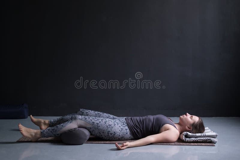 Vrouw uitwerken, die yogaoefening op houten vloer doen, die in Shavasana liggen stock afbeeldingen Vrouw uitwerken, die yogaoefening op houten vloer doen, die in Shavasana liggen stock afbeeldingen