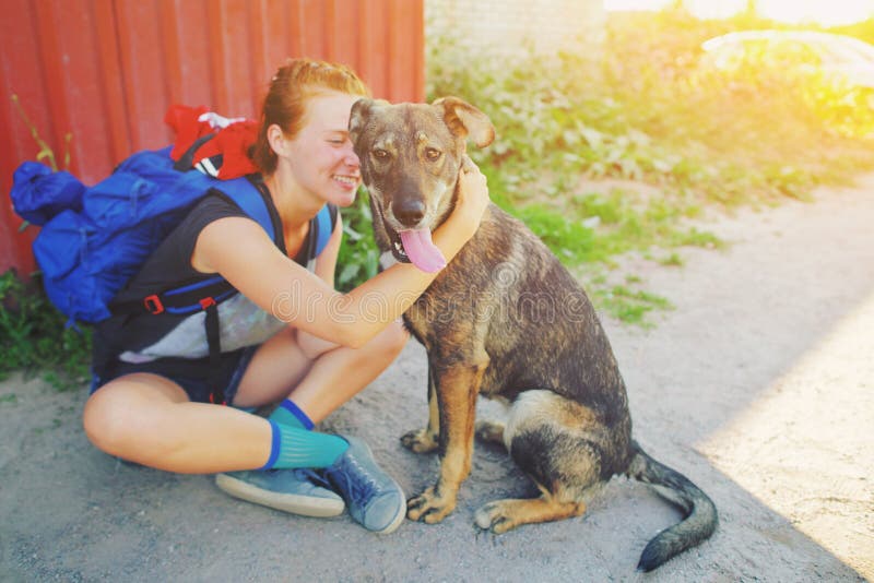 Vrouw van portret de jonge hipster met rugzak het kussen hond in openlucht Gelukkig huisdier en de aantrekkelijke Positieve mens royalty-vrije stock afbeeldingen Vrouw van portret de jonge hipster met rugzak het kussen hond in openlucht Gelukkig huisdier en de aantrekkelijke Positieve mens royalty-vrije stock afbeeldingen