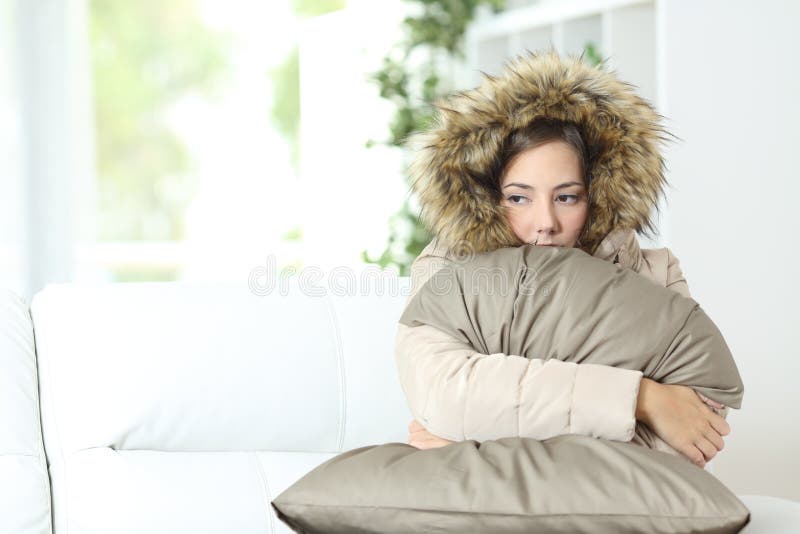 Vrouw warm gekleed in een koud huis