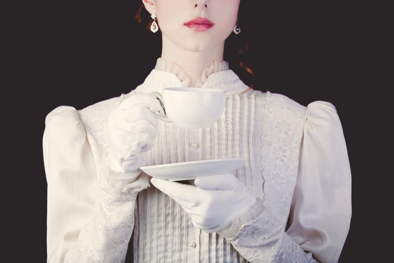 Vrouw in witte Victoriaanse erakleren met kop thee