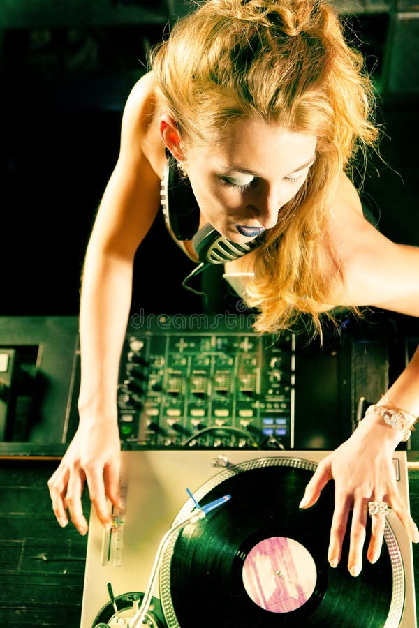 Vrouwelijk DJ bij de draaischijf in Club