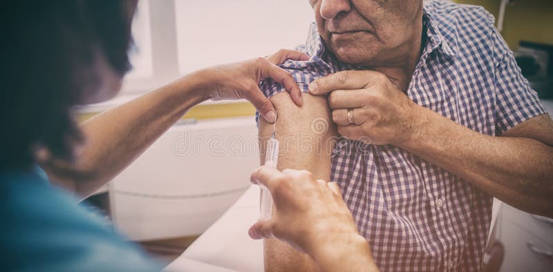 Vrouwelijke arts die een injectie geven aan een patiënt royalty-vrije stock afbeelding Vrouwelijke arts die een injectie geven aan een patiënt royalty-vrije stock afbeelding