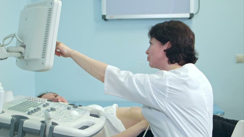 Vrouwelijke arts die ultrasone klankresultaten tonen aan haar patiënt