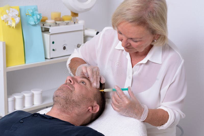 Vrouwelijke Arts Giving Injection aan Patiënt royalty-vrije stock afbeeldingen Vrouwelijke Arts Giving Injection aan Patiënt royalty-vrije stock afbeeldingen