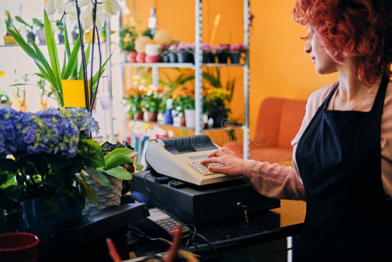 Vrouwelijke bloemverkoper die kasregister in een marktwinkel gebruiken royalty-vrije stock afbeeldingen Vrouwelijke bloemverkoper die kasregister in een marktwinkel gebruiken royalty-vrije stock afbeeldingen
