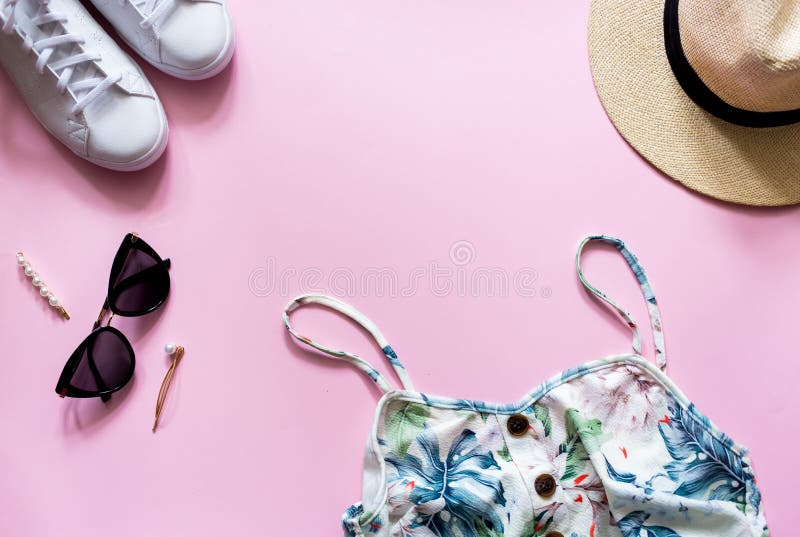 Vrouwelijke de zomeruitrusting op roze backgroud Gedrukte de zomerkleding met strohoed, zonnebril en witte tennisschoenen stock fotografie Vrouwelijke de zomeruitrusting op roze backgroud Gedrukte de zomerkleding met strohoed, zonnebril en witte tennisschoenen stock fotografie