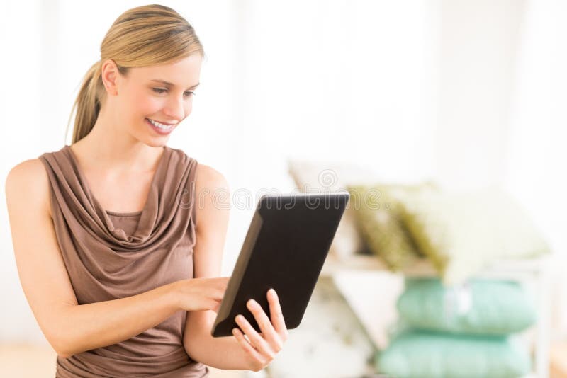 Vrouwelijke Eigenaar die Digitale Tablet in Beddegoedopslag gebruiken
