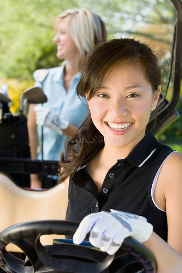 Female golfer sitting in golf cart. Female golfer sitting in golf cart