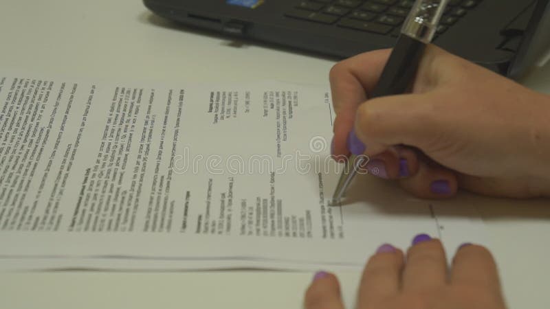 Een vrouwelijke hand tekent een contract stock footage