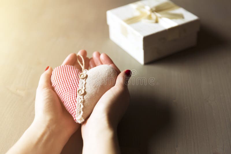 Vrouwelijke hand die een giftdoos houdt Een gift van een hart, liefdadigheid, cas stock foto Vrouwelijke hand die een giftdoos houdt Een gift van een hart, liefdadigheid, cas stock foto