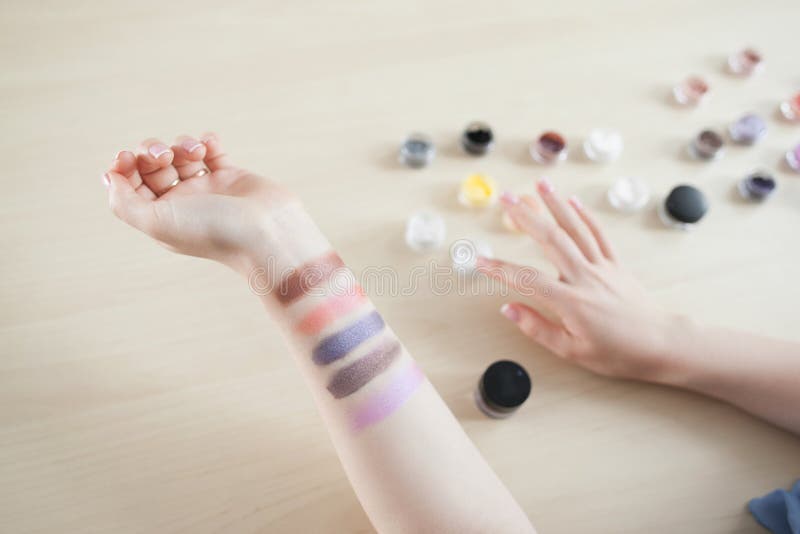 Vrouwelijke hand met kleurrijke oogschaduwvlekken stock fotografie Vrouwelijke hand met kleurrijke oogschaduwvlekken stock fotografie