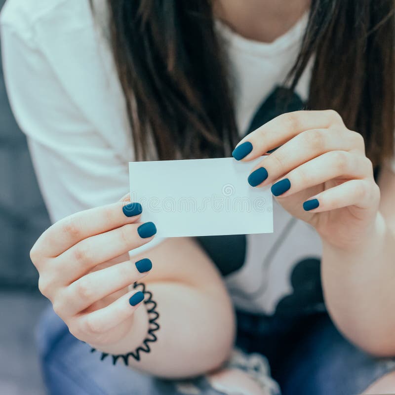 Vrouwelijke handen die wit leeg adreskaartje houden Manicure met diep turkoois blauw nagellak Gestemde foto royalty-vrije stock afbeelding Vrouwelijke handen die wit leeg adreskaartje houden Manicure met diep turkoois blauw nagellak Gestemde foto royalty-vrije stock afbeelding