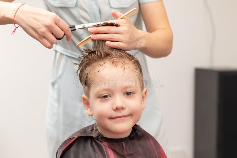 bereiken Geleerde inleveren Vrouwelijke Handen Van Een Moeder Met Een Kamper En Schaar Maken Een  Modieus Kapsel Voor Haar Zoon Thuis Tijdens De Tweede Blokker Stock Foto -  Image of droger, leuk: 221912322