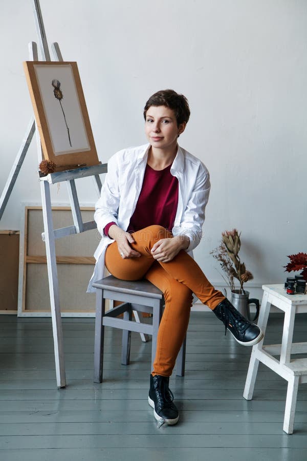 Vrouwelijke kunstenaar in haar ruime witte studio die met waterverf het schilderen werken stock afbeeldingen Vrouwelijke kunstenaar in haar ruime witte studio die met waterverf het schilderen werken stock afbeeldingen