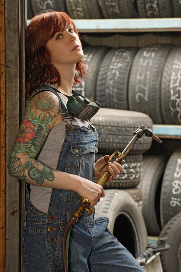 Vrouwelijke lasser met tatoegeringen stock fotografie Vrouwelijke lasser met tatoegeringen stock fotografie