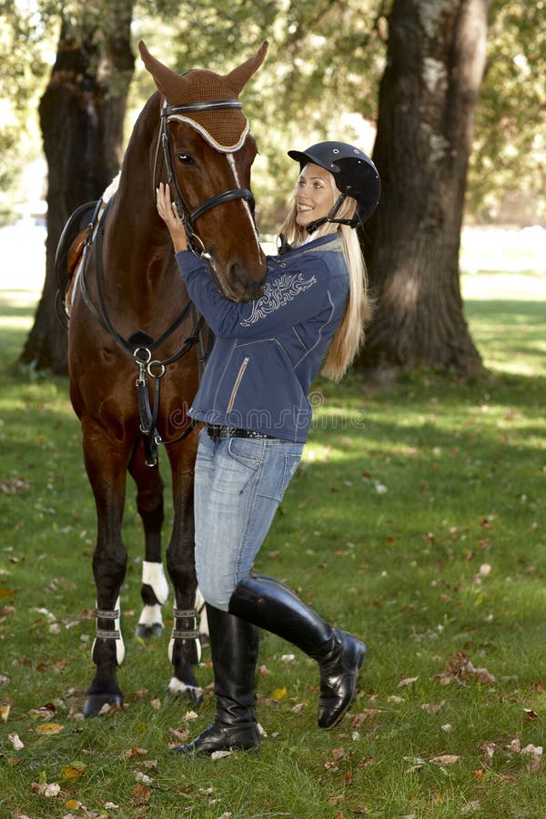 Vrouwelijke ruiter die paard omhelzen stock foto Vrouwelijke ruiter die paard omhelzen stock foto