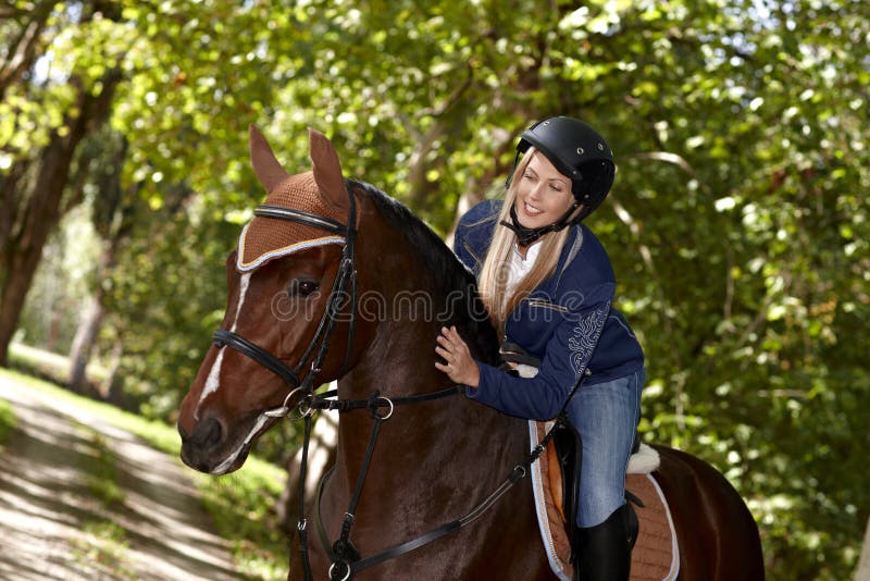 Vrouwelijke ruiter die paard strelen stock foto Vrouwelijke ruiter die paard strelen stock foto