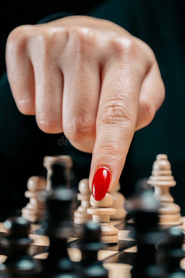 Vrouwelijke speler die bordspel speelt. vrouwelijke arm met rode nagels beweegt het stuk in eerste beweging