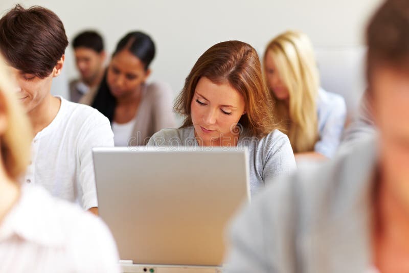 Female student working at laptop in university. Female student working at laptop in university